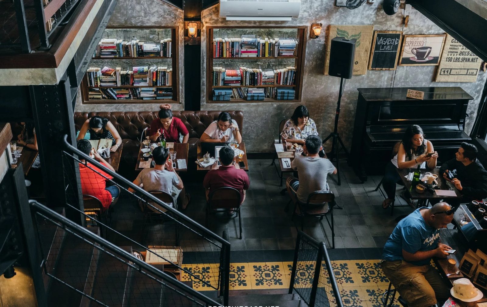 Pison Petitenget — overhead view of dining room, bookshelves, leather banquettes, encaustic tile floor